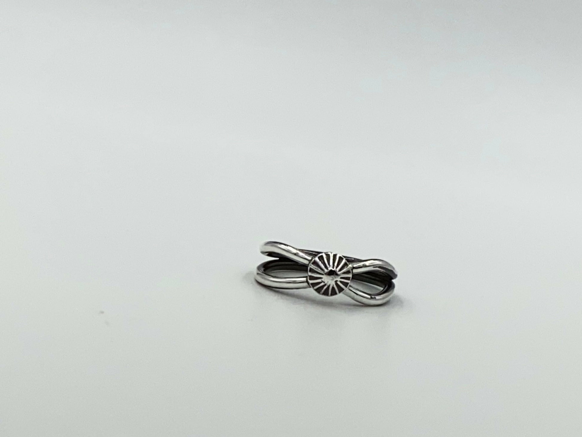 Split shank ring with center focal of a spiral ornated silver pendent. Small and dainty
