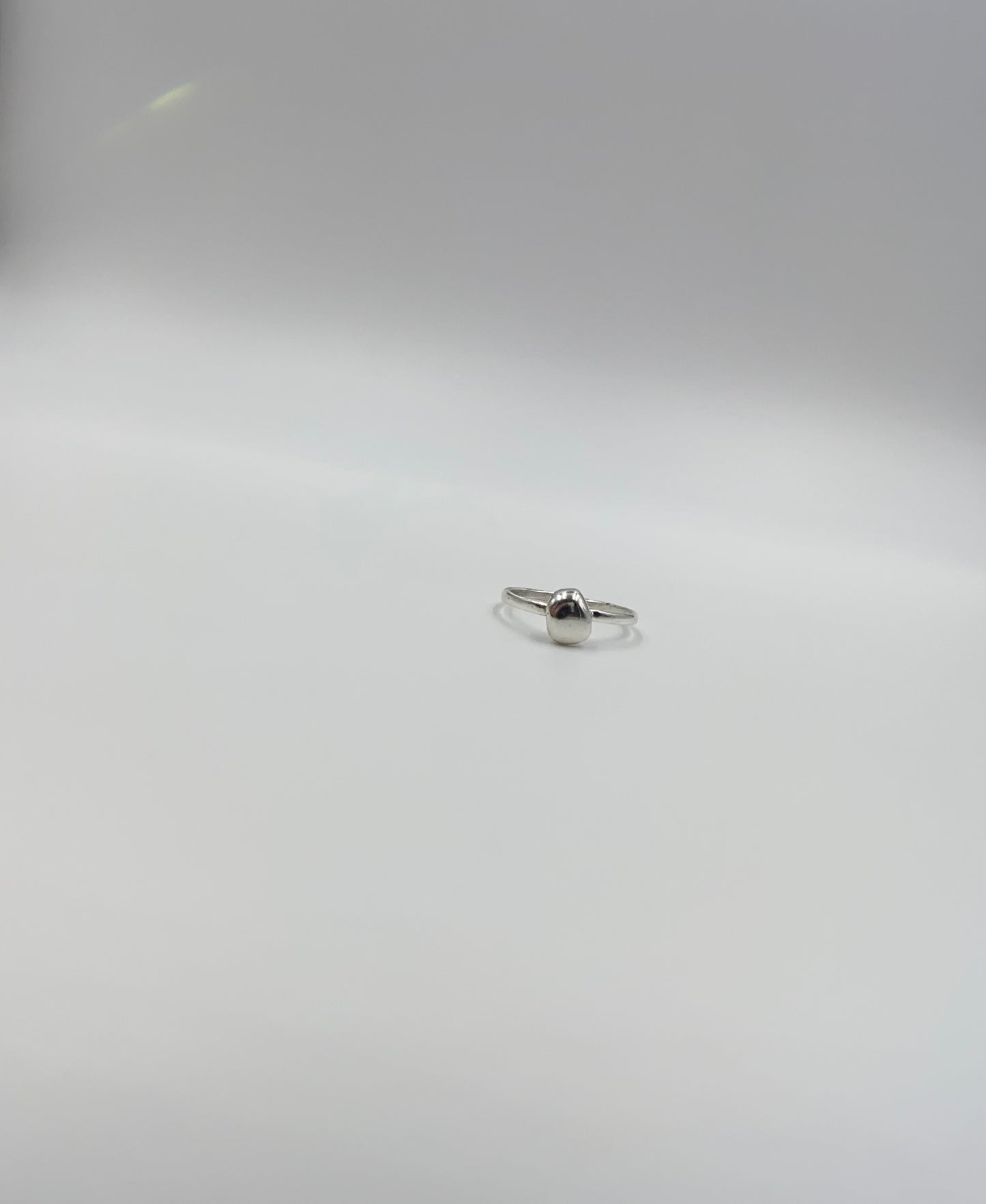 Organic sterling silver ring with large bump of silver resembling a raindrop as the focal, super simple straight band.