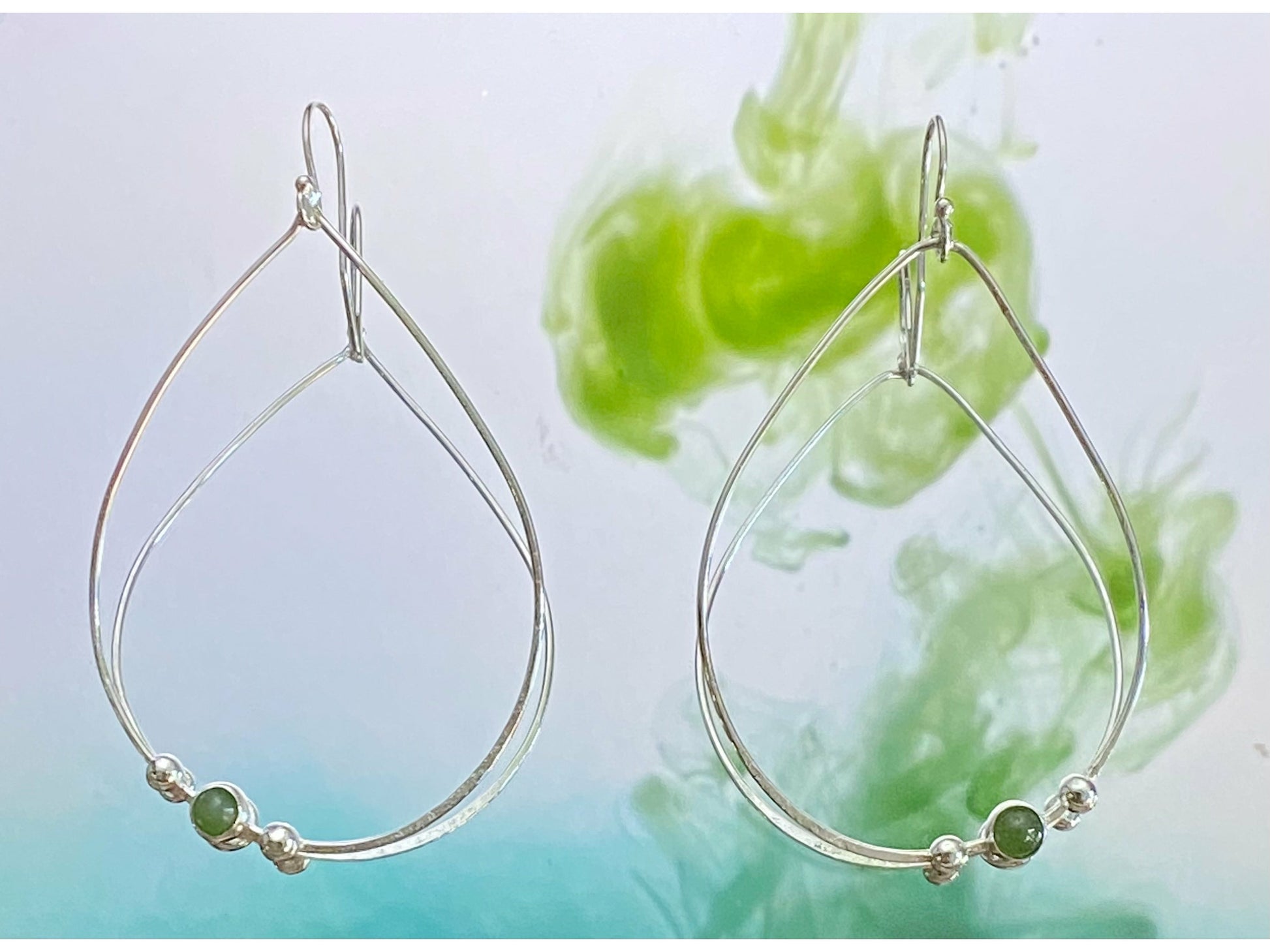 Teardrop gold or silver earrings with two dots of silver or gold offset to the left with a jade 3mm stone. Offset to the right in the right earring