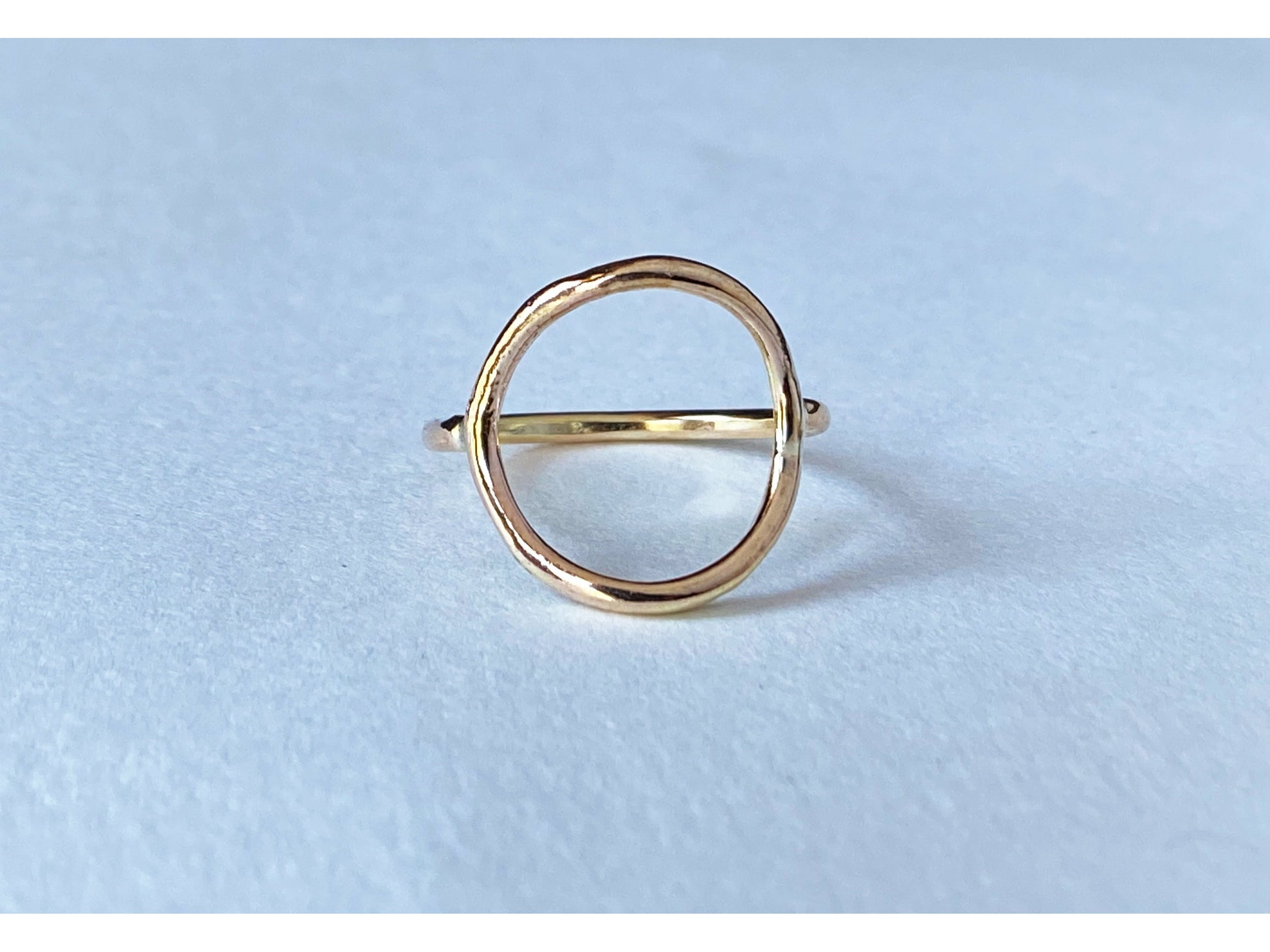 Circle ring in either silver or gold. Band meets the circle on the left and right size, open circle no back.