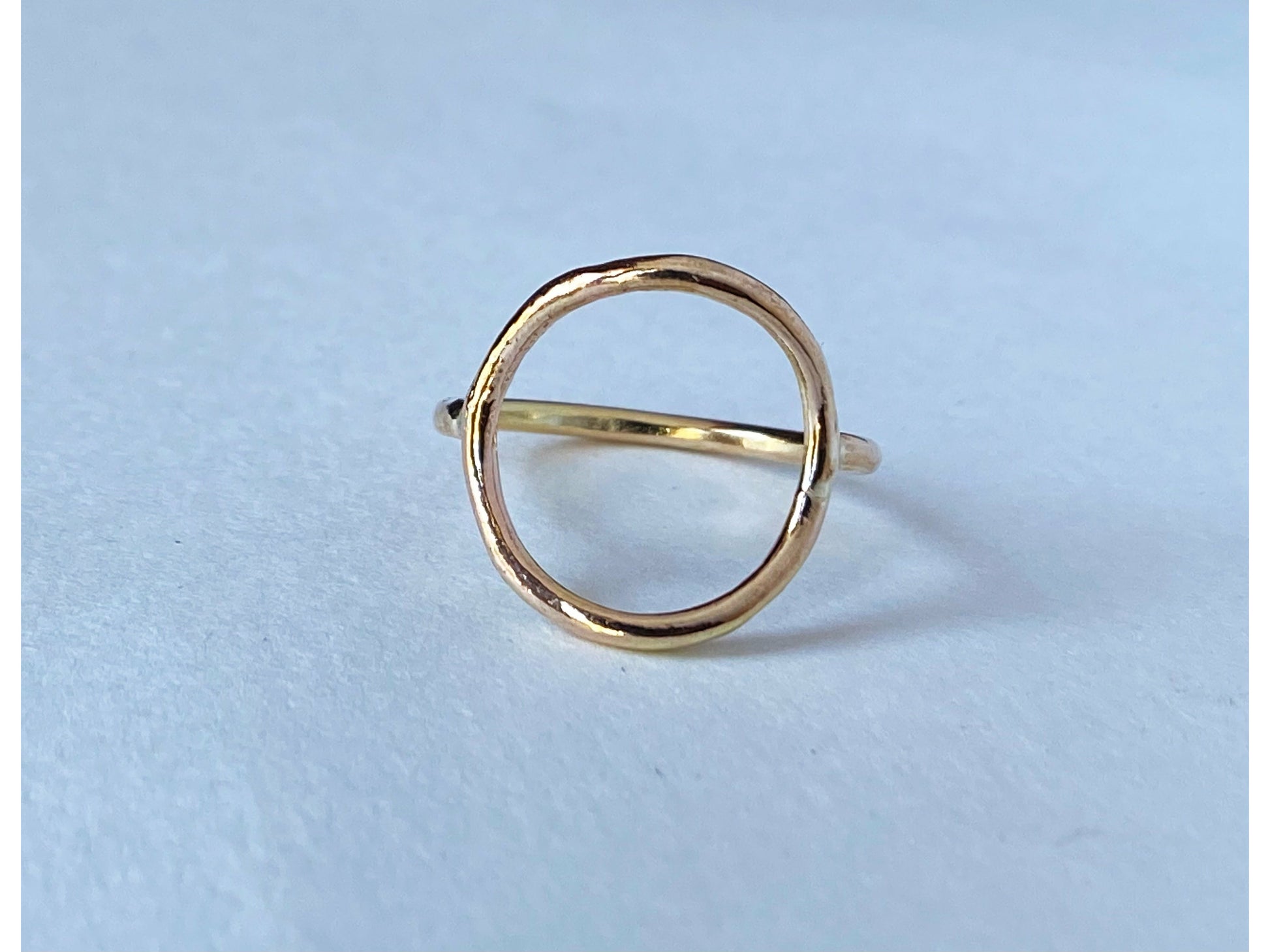 Circle ring in either silver or gold. Band meets the circle on the left and right size, open circle no back.