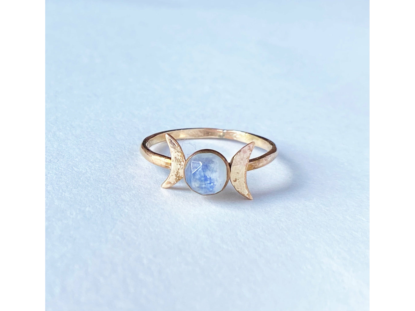 Two moons on the left and right of the stone, moonstone set at focal. Made out of gold filled.